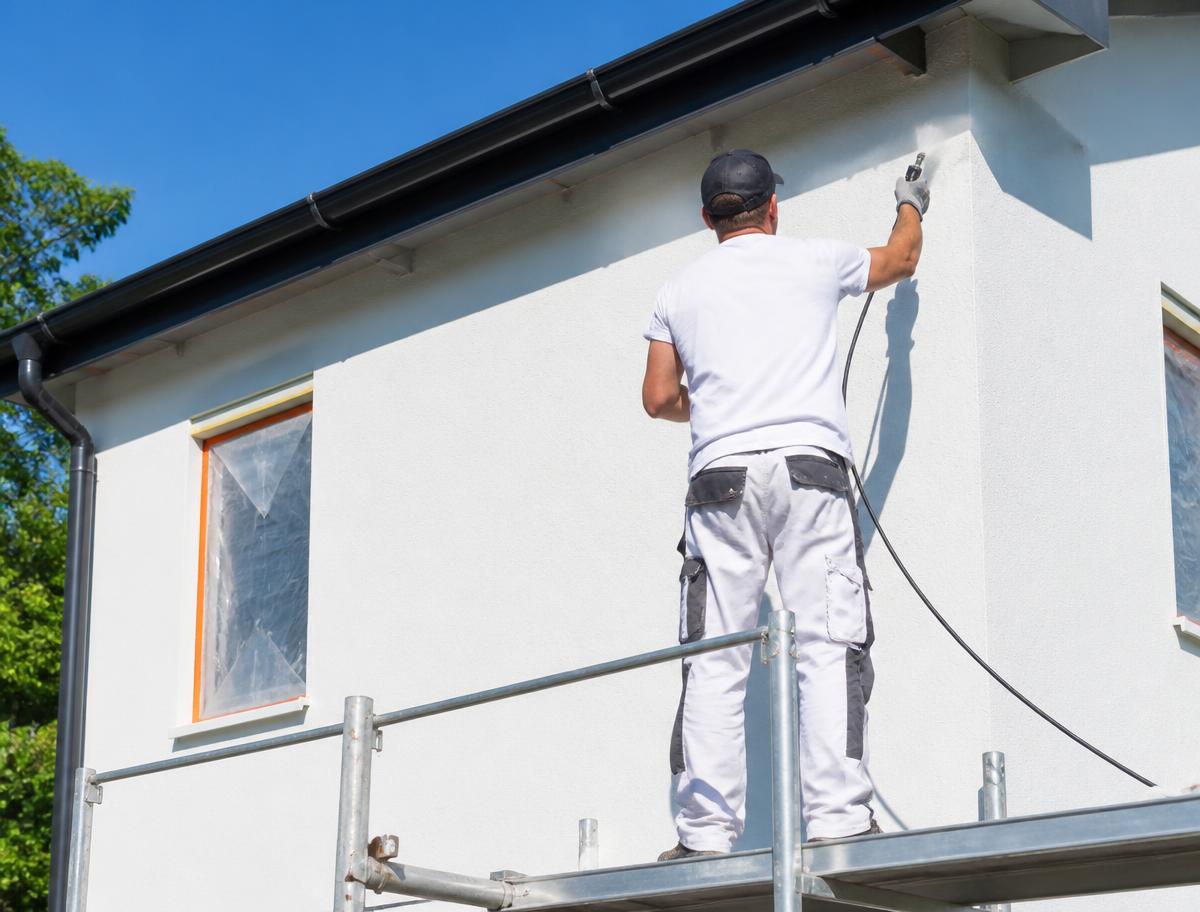 Peinture d'une façade de maison depuis un échafaudage